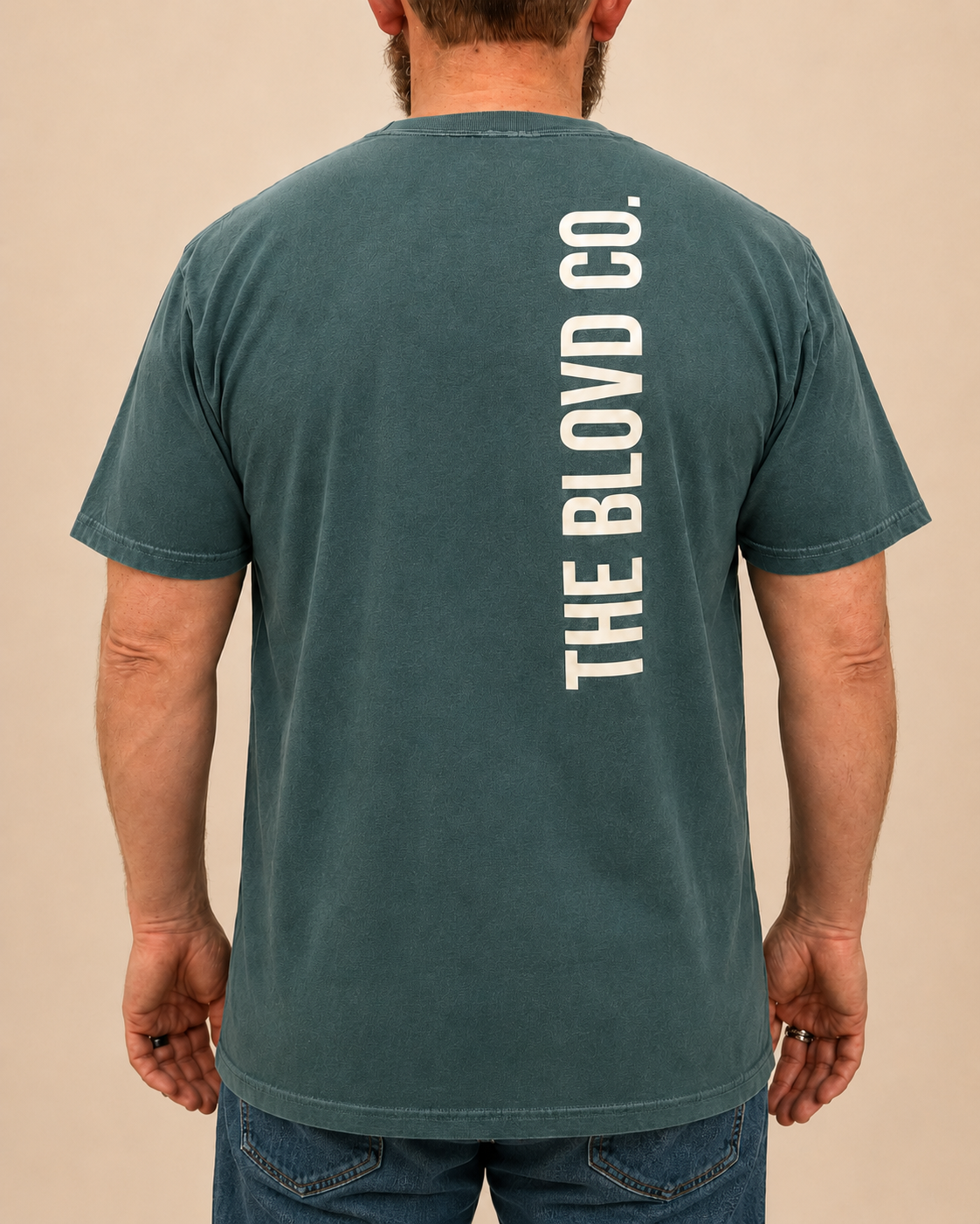 THE BLOVD Lion Signature on Comfort Colors 1717 Blue Spruce with Soft Linen vertical back wordmark, male rear view