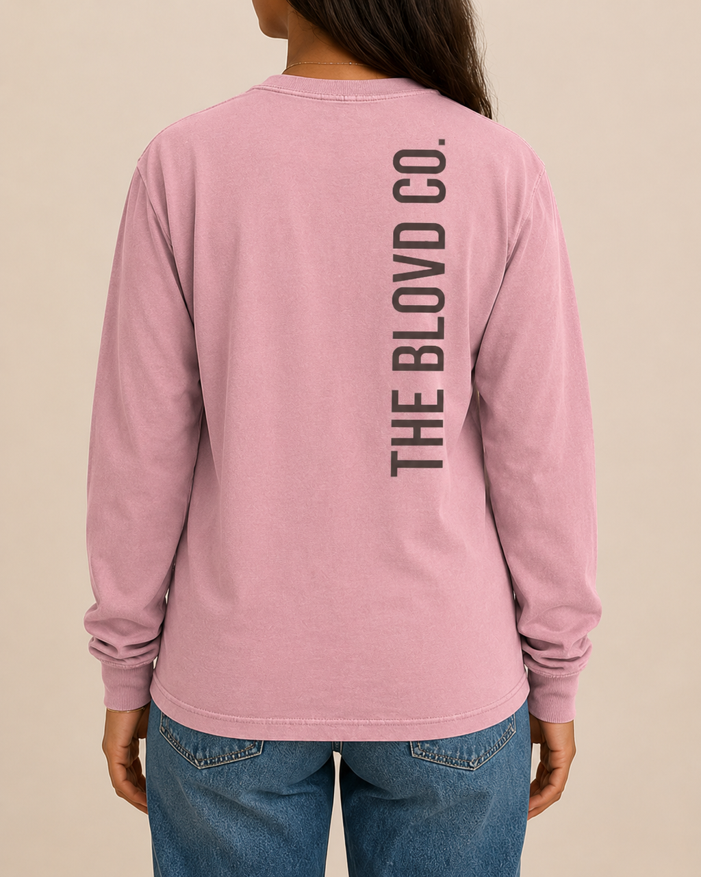 THE BLOVD Lion Signature Comfort Colors 6014 Blossom long sleeve with Deep Charcoal vertical THE BLOVD CO. back wordmark, approved female rear studio view
