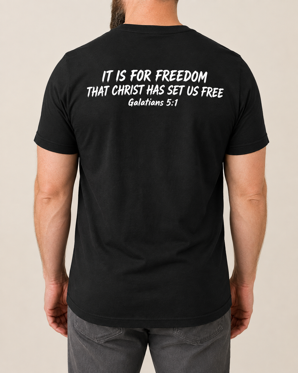 Freedom Galatians 5:1 Bella+Canvas Black tee with BLOVD Pure White Scripture artwork, approved male warm-neutral studio back view showing the back of the neck.