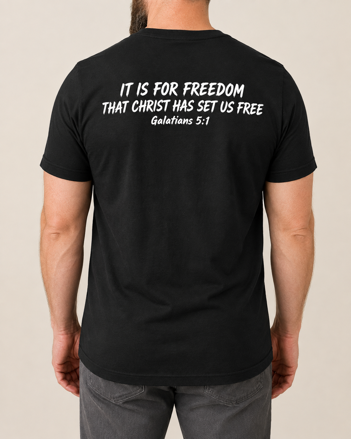Freedom Galatians 5:1 Bella+Canvas Black tee with BLOVD Pure White Scripture artwork, approved male warm-neutral studio back view showing the back of the neck.