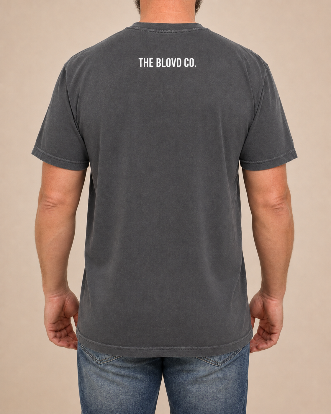 THE BLOVD Lion Classic Pepper Comfort Colors T-shirt with white THE BLOVD CO. upper-back mark, approved warm-neutral studio back view